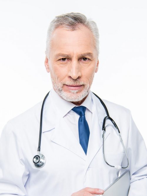smiling-mature-male-doctor-with-stethoscope-holding-laptop-isolated-on-white-e1625182645470.jpg