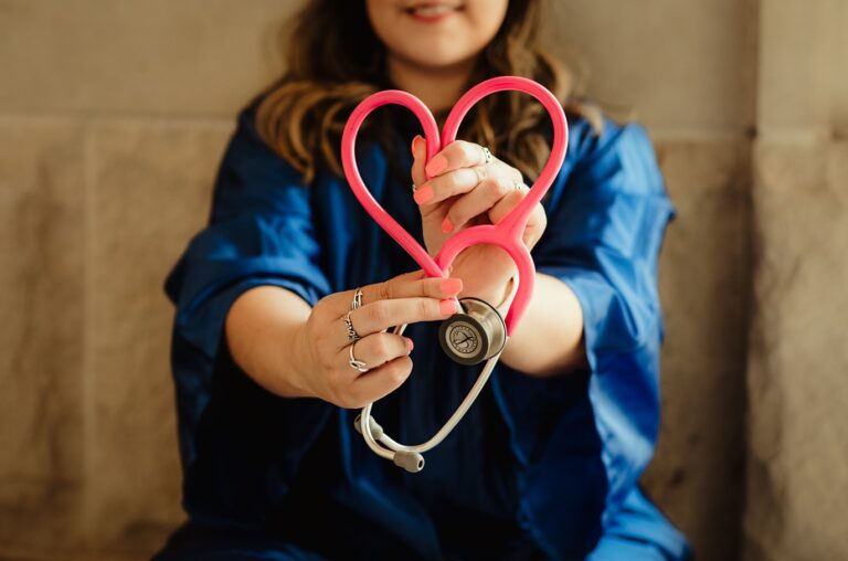 woman holding a pink stethoscope in shape of a heart